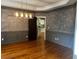 An elegant dining room with hardwood floors, chair rails, decorative walls, and a modern chandelier at 5679 Coopers Glen Ct, Mableton, GA 30126