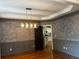 An elegant dining room with hardwood floors, chair rails, decorative walls, and a modern chandelier at 5679 Coopers Glen Ct, Mableton, GA 30126