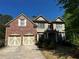 Charming two-story home featuring a brick facade, two-car garage, and manicured landscaping at 5679 Coopers Glen Ct, Mableton, GA 30126