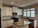 Stylish kitchen showcasing an island, white cabinets, stainless steel appliances, and granite countertops at 5679 Coopers Glen Ct, Mableton, GA 30126