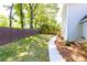 The spacious backyard is enclosed by a wooden fence and features a well-maintained lawn and landscaped pathway at 11140 Brookhollow Trl, Alpharetta, GA 30022