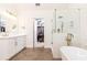 Bright bathroom features herringbone floors, glass shower, dual sink vanity, walk-in closet, and modern fixtures at 11140 Brookhollow Trl, Alpharetta, GA 30022