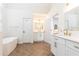 Bright bathroom features herringbone floors, standalone tub, dual sink vanity, and modern fixtures at 11140 Brookhollow Trl, Alpharetta, GA 30022