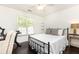 Bright bedroom featuring a large window, ceiling fan, and bedside table for comfort and convenience at 11140 Brookhollow Trl, Alpharetta, GA 30022