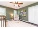 Cozy Bedroom with crib, chair, and shelves stocked with books, ceiling fan, and green walls at 11140 Brookhollow Trl, Alpharetta, GA 30022