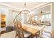 Dining room with large wood table and hardwood floors next to living room and staircase at 11140 Brookhollow Trl, Alpharetta, GA 30022