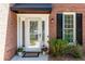 Elegant front door with decorative glass and a black awning, surrounded by brick at 11140 Brookhollow Trl, Alpharetta, GA 30022
