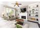 Inviting living room with fireplace, custom built-ins, neutral tones, and lots of natural light at 11140 Brookhollow Trl, Alpharetta, GA 30022