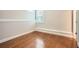 Bedroom with hardwood flooring, base molding, and large window at 1780 Morningtide Ne Ln, Atlanta, GA 30324