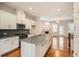 Open kitchen featuring granite counters, stainless appliances, island with sink, and a view into the living room at 1780 Morningtide Ne Ln, Atlanta, GA 30324