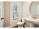 Classic powder room featuring pedestal sink, oval mirror, dark hardwood flooring and natural light at 1780 Morningtide Ne Ln, Atlanta, GA 30324