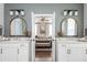 Elegant bathroom with dual sinks, arched mirrors, and access to the bedroom at 472 Burton Dr, Alpharetta, GA 30009