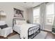 Stylish bedroom featuring a metal frame bed, neutral decor, and natural light at 472 Burton Dr, Alpharetta, GA 30009