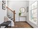 Inviting entryway with wood floors, stairs, wood and iron railings, bench, decor and natural light at 472 Burton Dr, Alpharetta, GA 30009