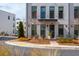 Charming townhome featuring a painted brick facade, black framed windows and tasteful landscaping at 472 Burton Dr, Alpharetta, GA 30009