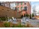 Outdoor seating area with a brick fire pit surrounded by white chairs and manicured landscaping at 472 Burton Dr, Alpharetta, GA 30009