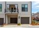 Stylish townhome featuring private garages with a cozy balcony, enhancing the property's curb appeal at 472 Burton Dr, Alpharetta, GA 30009