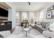 Well-lit living room with designer furnishings, a modern media center, and plenty of natural light at 472 Burton Dr, Alpharetta, GA 30009