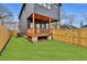 Spacious backyard with green grass, wooden fence, and a covered back porch at 701 Smith St, Atlanta, GA 30310