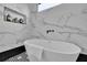 Elegant bathroom showcasing a modern white soaking tub with marble tile surround and black fixtures at 701 Smith St, Atlanta, GA 30310