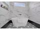 Luxurious bathroom with a soaking tub, marble tile walls, black fixtures, and a geometric tile floor at 701 Smith St, Atlanta, GA 30310