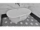 Close-up of a sleek white soaking tub on a geometric tile floor, complemented by elegant black fixtures at 701 Smith St, Atlanta, GA 30310