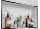Stylish shower niche displaying decorative bottles and potted cacti set against a marble-tiled background at 701 Smith St, Atlanta, GA 30310