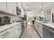 Modern kitchen with stainless steel appliances, white cabinetry, and a view into the dining and living areas at 106 Holt Ln, Lawrenceville, GA 30046