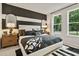 Stylish bedroom with a striped accent wall, chic furniture, and natural light from two windows at 106 Holt Ln, Lawrenceville, GA 30046