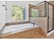 A modern bathroom includes a soaking tub, a glass shower and a window at 120 Generals Pl, Canton, GA 30114