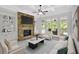Cozy living room featuring a stone fireplace, built-in shelves, a ceiling fan, and large windows at 120 Generals Pl, Canton, GA 30114