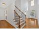 Elegant staircase with wooden steps, iron railings, and an arched doorway leading into a spacious living area at 120 Generals Pl, Canton, GA 30114