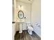 Well-lit half bath with a pedestal sink, modern toilet, and elegant fixtures, ideal for guests at 235 Centennial Cir, Canton, GA 30114