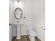 Bright bathroom with pedestal sink, oval mirror, and modern fixtures at 235 Centennial Cir, Canton, GA 30114