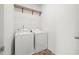 Functional laundry room equipped with washer, dryer, and overhead shelving for storage at 235 Centennial Cir, Canton, GA 30114
