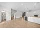 Open-concept living room featuring wood floors, fireplace, and modern kitchen with stainless steel appliances at 235 Centennial Cir, Canton, GA 30114