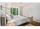 Bedroom with hardwood floors, large window with backyard views, and white closets at 2361 Woodward Nw Way, Atlanta, GA 30305