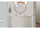 Bathroom featuring double sinks with a unique round mirror, white cabinets and a tiled shower at 2361 Woodward Nw Way, Atlanta, GA 30305