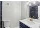 Bathroom featuring a toilet, vanity and tiled shower with blue accents at 3344 Northcrest Rd # A, Atlanta, GA 30340
