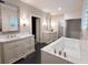 Bathroom featuring double vanities, a soaking tub, and a glass-enclosed shower, offering a luxurious experience at 1299 W Wesley Nw Rd, Atlanta, GA 30327