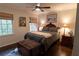 A cozy bedroom with a ceiling fan, bedside tables with lamps, and a decorative bench at the end of the bed at 1299 W Wesley Nw Rd, Atlanta, GA 30327