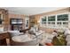 Bright living room features a stone fireplace, wood-paneled walls, and large windows overlooking the backyard at 1299 W Wesley Nw Rd, Atlanta, GA 30327