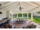 Covered patio with comfortable seating, brick floor, ceiling fan, and views of the manicured backyard at 1299 W Wesley Nw Rd, Atlanta, GA 30327