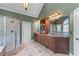 A spacious bathroom is complete with a glass shower, double vanity, and decorative sconces at 2111 Democracy Dr, Buford, GA 30519