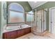 Bright bathroom features a large soaking tub, frosted window, and glass enclosed shower at 2111 Democracy Dr, Buford, GA 30519