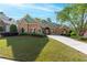 Beautiful stone house featuring lush green lawn, mature landscaping and well maintained lawn at 2111 Democracy Dr, Buford, GA 30519