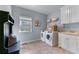 Well-equipped laundry room featuring modern washer and dryer, ample storage, and utility sink at 2111 Democracy Dr, Buford, GA 30519