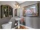 Elegant powder room with pedestal sink, decorative cabinet, and framed artwork at 2111 Democracy Dr, Buford, GA 30519
