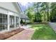 Manicured backyard with patio seating, a lush lawn, brick pathway, and a serene treeline at 436 Westlake Nw Dr, Marietta, GA 30064