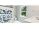 Bright bathroom with a decorative butterfly shower curtain, sink, toilet, and window with tree view at 436 Westlake Nw Dr, Marietta, GA 30064